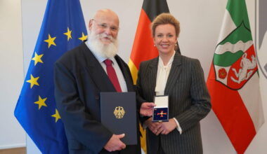 Die Ministerin für Kultur und Wissenschaft des Landes Nordrhein-Westfalen, Ina Brandes, übergibt das Bundesverdienstkreuz an Altrektor Marcus Baumann.