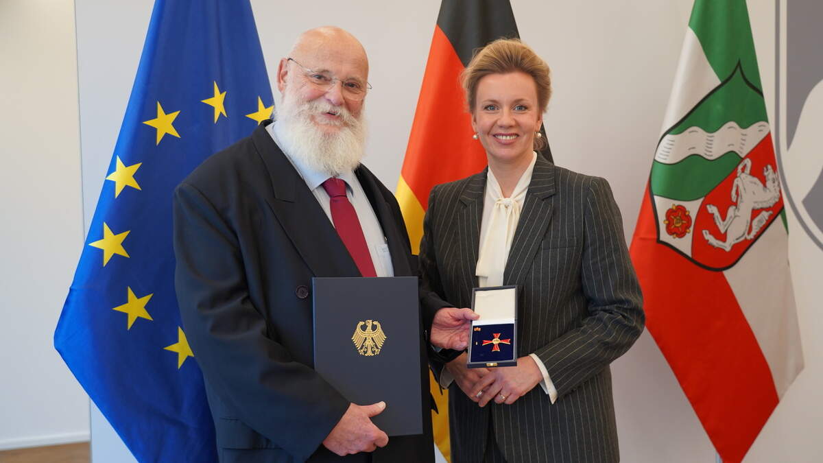 Die Ministerin für Kultur und Wissenschaft des Landes Nordrhein-Westfalen, Ina Brandes, übergibt das Bundesverdienstkreuz an Altrektor Marcus Baumann.