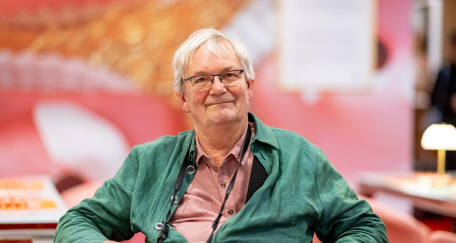 Der britische Magnum-Fotograf Martin Parr sitzt in der Ausstellung "Grand Hotel Parr" - Fotobücher von Martin Parr, im Neuen Museum Nürnberg (NMN) im "Dining Room".