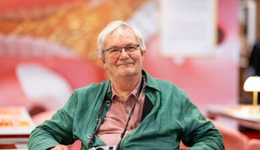 Der britische Magnum-Fotograf Martin Parr sitzt in der Ausstellung "Grand Hotel Parr" - Fotobücher von Martin Parr, im Neuen Museum Nürnberg (NMN) im "Dining Room".