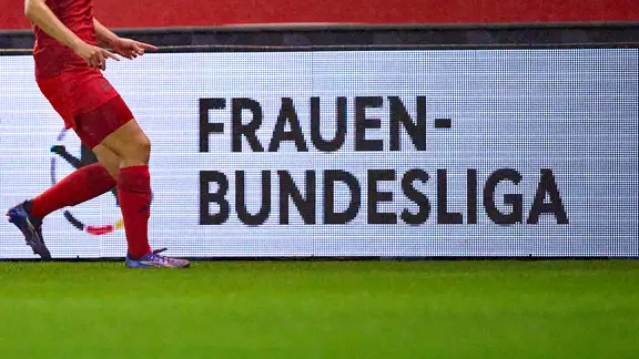Das Logo der Frauenfußball-Bundesliga auf einer Werbebande | IMAGO/ActionPictures Das Logo der Frauenfußball-Bundesliga auf einer Werbebande