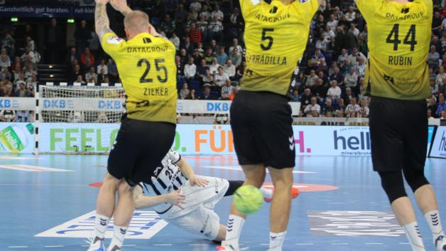 Hier fliegt der von Eric Johansson (hinten halb verdeckt) geworfene Freiwurf zwischen Patrick Zieker (vorne links) und Antonio Serradilla (Mitte) vom TVB Stuttgart hindurch ins Tor. Rechts verfolgt TVB-Akteur Lenny Rubin die Aktion.