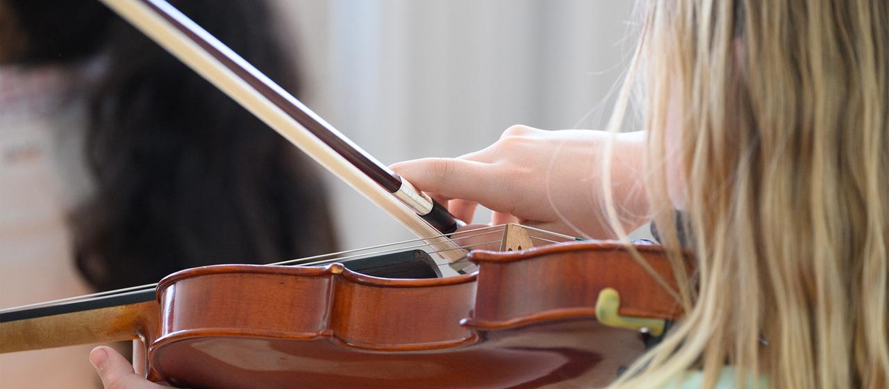 Ein Mädchen spielt auf einer Geige.