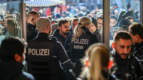 Nach dem Einbruch wollten rund 200 aufgebrachte Kunden in die betroffene Filiale. | Christoph Reichwein/dpa Kunden versuchen in eine Sparkassenfiliale in Gelsenkirchen-Buer zu gelangen.