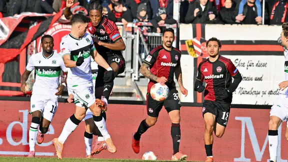 Hannovers Enzo Leopold (2.v.l.) im Duell mit Nürnbergs Pape Demba Diop (M.).