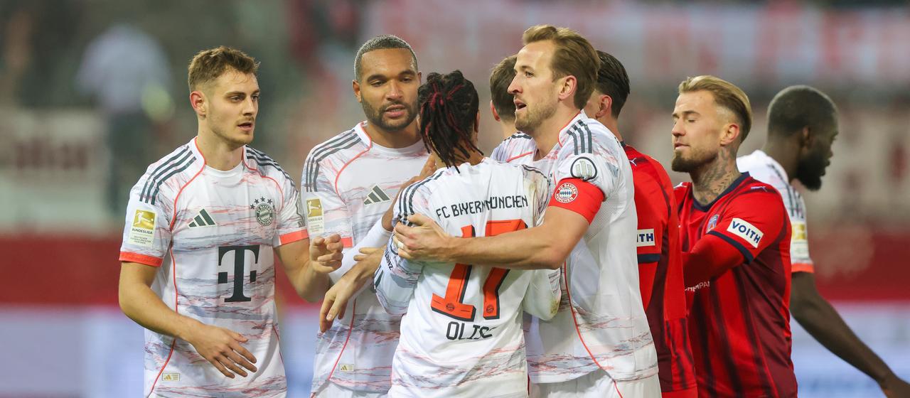 Harry Kane (4. v. l.) muss Michael Olise im Spiel gegen Heidenheim zurückhalten (3. v. l.)