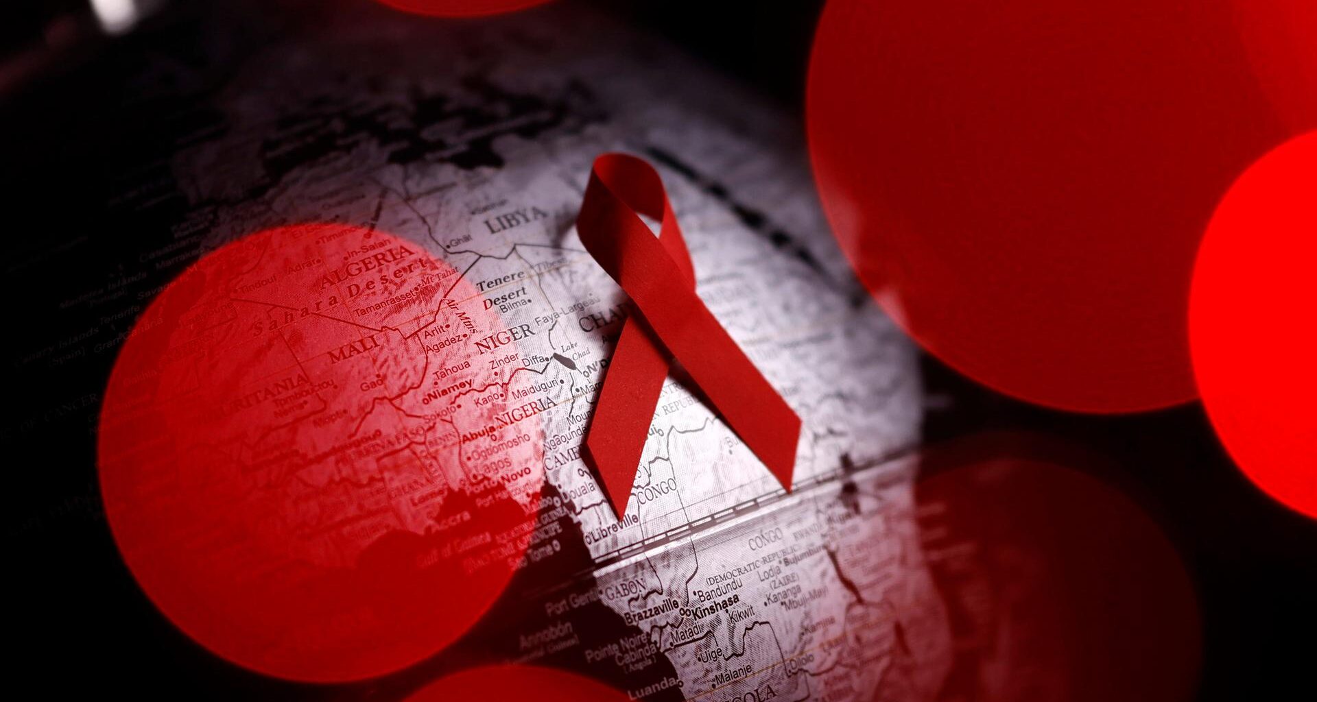 Symbolbild: Der Welt-AIDS-Tag wird jährlich vom Gemeinsamen Programm der Vereinten Nationen. Eine rote Schleife.