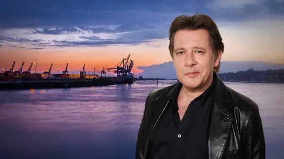 Collage: Jan Fedder vor dem Hamburger Hafen im Sonnenuntergang.