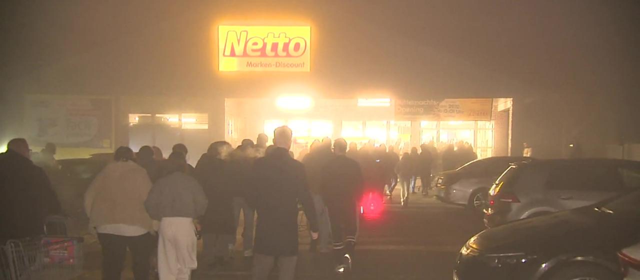 Menschen stehen Schlange vor einem Supermarkt in Kleve.