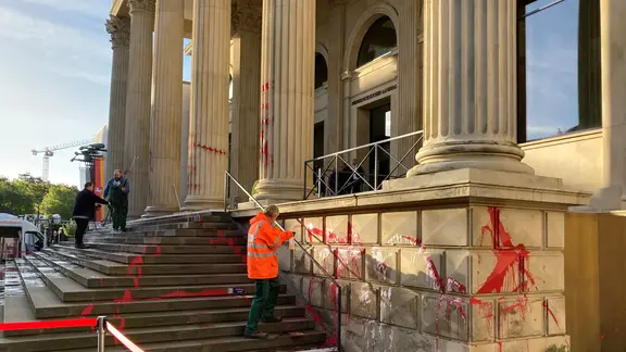 Reinigungskräfte entfernen Farbschmierereien am Niedersächsischen Landtag.