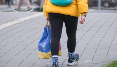 Eine Person mit einer Einkaufstüte in der Hand.