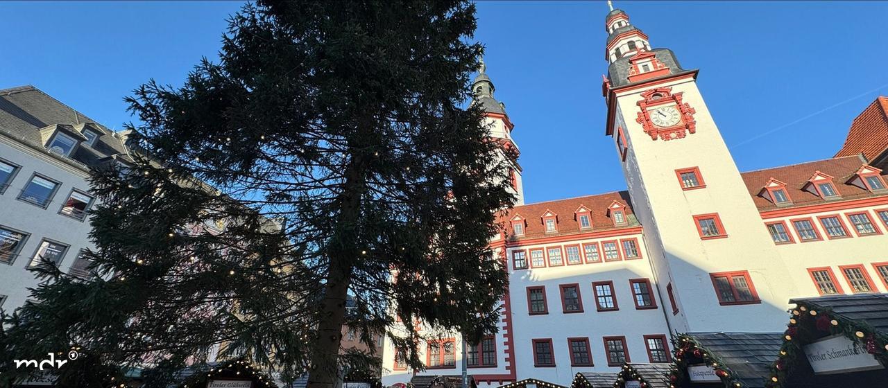 Blick auf den Chemnitzer Weihnachtsmarkt mit Baum und Rathausturm.