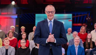 Bundeskanzler Friedrich Merz (CDU) steht vor der Live-Sendung der ARD-"Arena" in der Lemo Kulturhalle. Im Hintergrund sitzen Zuschauerinnen und Zuschauer.