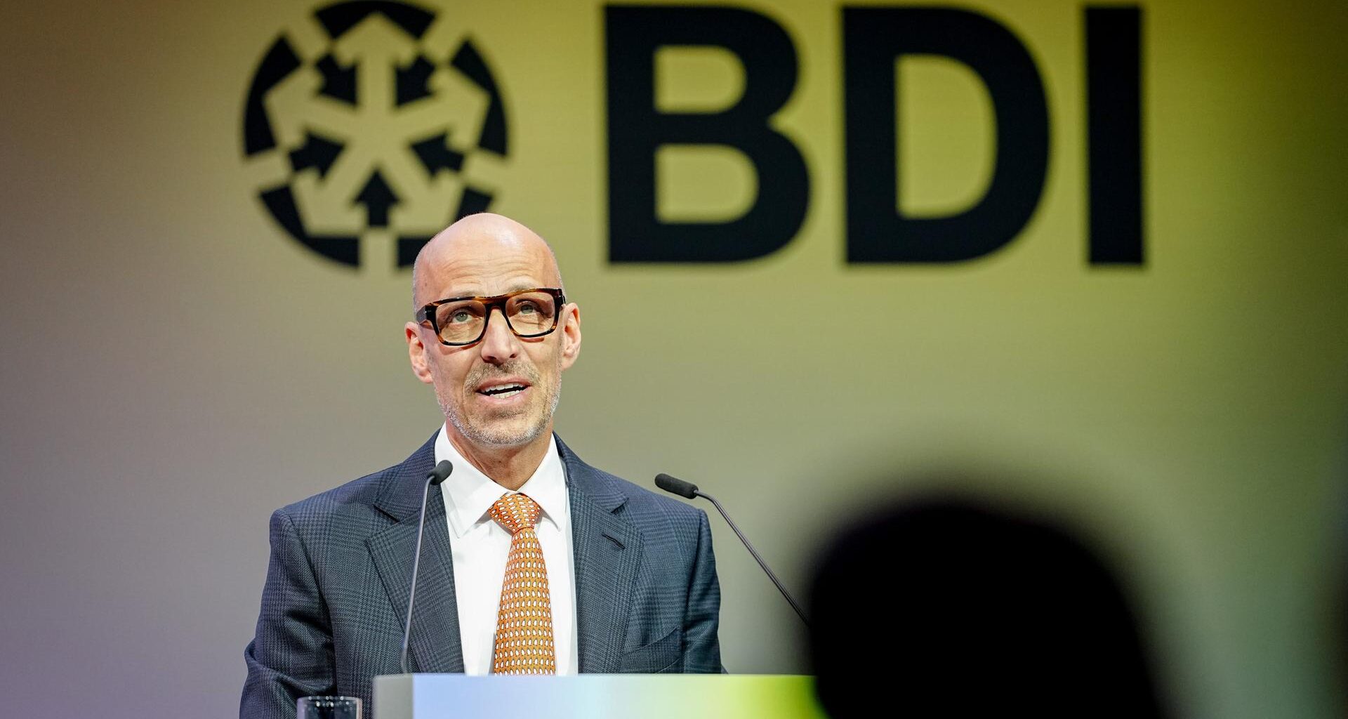 Peter Leibinger, Präsident des Bundesverbands der Deutschen Industrie, spricht in ein Mikrofon vor Publikum.