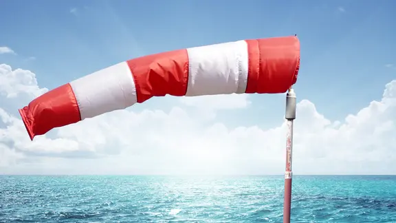 Wetterfahne und Meer mit blauem Himmel (Bildmontage)