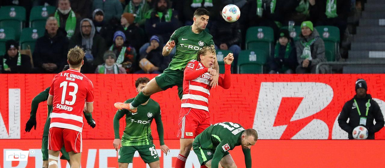 Audio: Die Vollreportage zum Nachhören | imago images/regios24 Unions Leo Querfeld im Kopfballduell mit Wolfsburgs Konstantinos Koulierakis. Quelle: imago images/regios24