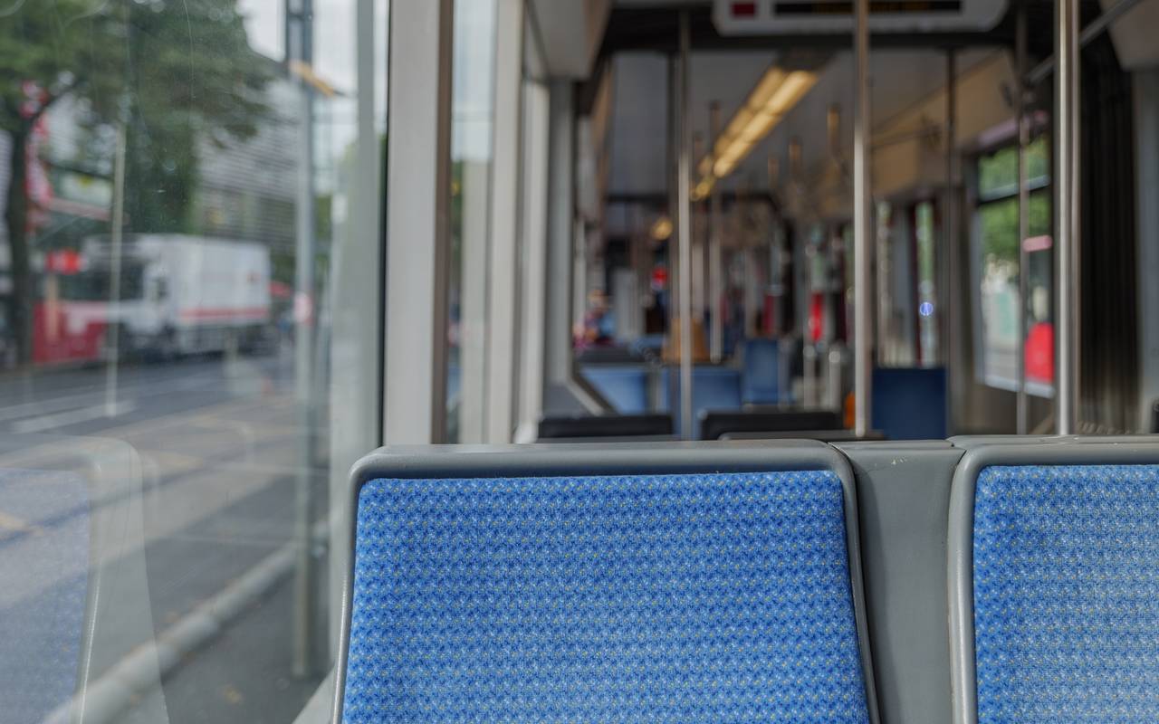 Innenansicht einer Straßenbahn der Rheinbahn. Die Sitze sind leer und blau.