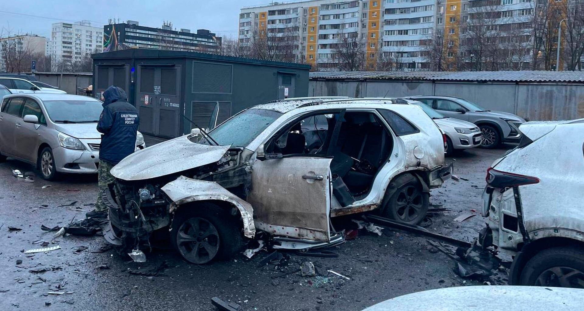 Ein Ermittler arbeitet am Tatort, an dem eine Bombe ein Auto zerstört hat.