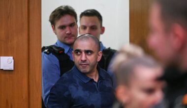 Ein Angeklagter wird von Polizisten in den Gerichtssaal geführt.