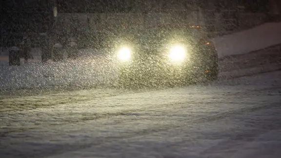 Autoscheinwerfer dringen durch dichtes Schneetreiben in Hamburg (Archiv).