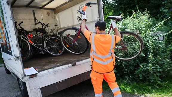 Ein Mitarbeiter der Stadtreinigung Hamburg stellt Schrottfahrräder in einen Lastwagen. | picture alliance/dpa | Christian Charisius, Christian Charisius Ein Mitarbeiter der Stadtreinigung Hamburg stellt Schrottfahrräder in einen Lastwagen.