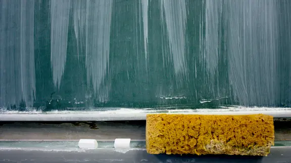 Eine Schultafel, darunter ein Schwamm und Kreide. | ohneski / photocase.de, ohneski / photocase.de Eine Schultafel, darunter ein Schwamm und Kreide.