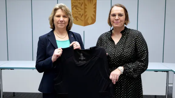 Kerstin von der Decken und Mareile Dufke präsentieren eine Schutzweste für Gerichtsvollzieher.