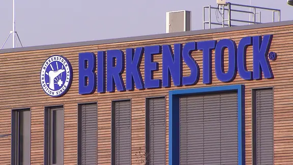Der Schriftzug "Birkenstock" ist an einer Werkshalle in Pasewalk angebracht.