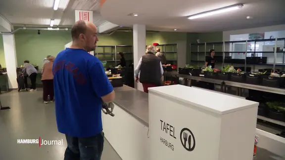 Ein Mann steht am Tresen im Gebäude der Tafel.