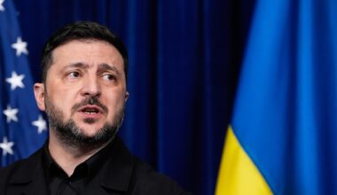 Wolodymyr Selensky spricht während einer Pressekonferenz, dahinter zu sehen sind eine amerikanische und eine ukrainische Flagge.