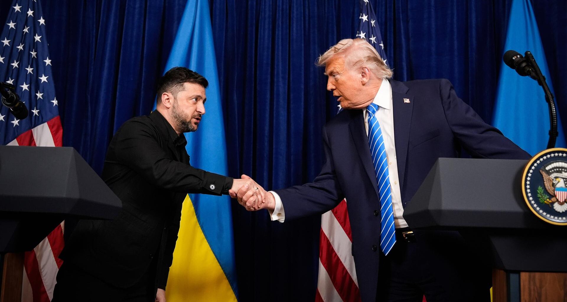 US-Präsident Donald Trump (r) und Wolodymyr Selenskyj, Präsident der Ukraine, geben sich zu Beginn einer gemeinsamen Pressekonferenz nach einem Treffen in Trumps Mar-a-Lago-Club die Hand.