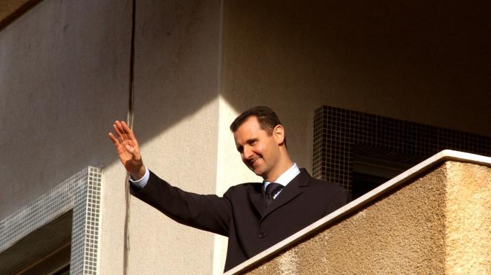 Ein Mann winkt von einem Balkon