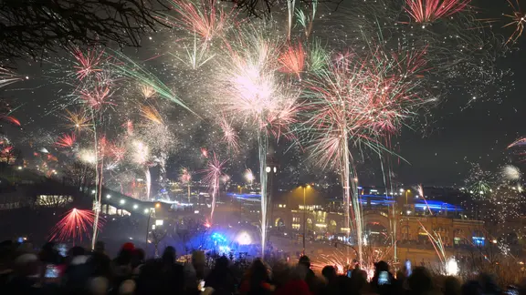 Zahlreiche Menschen feiern mit Feuerwerk den Jahreswechsel an den Landungsbrücken im Hamburger Hafen. | picture alliance/dpa | Marcus Brandt, Marcus Brandt Zahlreiche Menschen feiern mit Feuerwerk den Jahreswechsel an den Landungsbrücken im Hamburger Hafen.