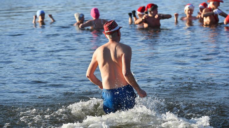 Zahlreiche Wasserfreunde nehmen am Weihnachtsbaden des Vereins Berliner Seehunde im Orankesee teil. Bei Minusgraden und einer Wassertemperatur von knapp einem Grad hielten es die Teilnehmer aber nur kurz im Wasser aus. (Quelle: dpa/Zinken)