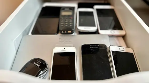 Alte Smartphones in einer Schublade.