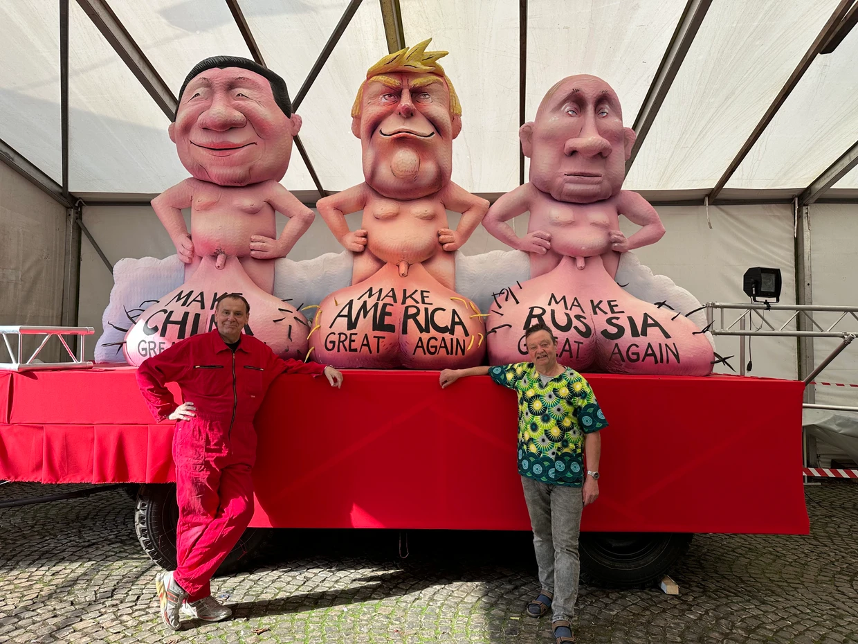 Steht für den Umzug in Babenhausen bereit: Jacques Tilly (links) mit Norbert Biba vor dem Motivwagen aus der vergangenen Kampagne mit Putin, Donald Trump und dem chinesischen Staatspräsidenten Xi Jinping