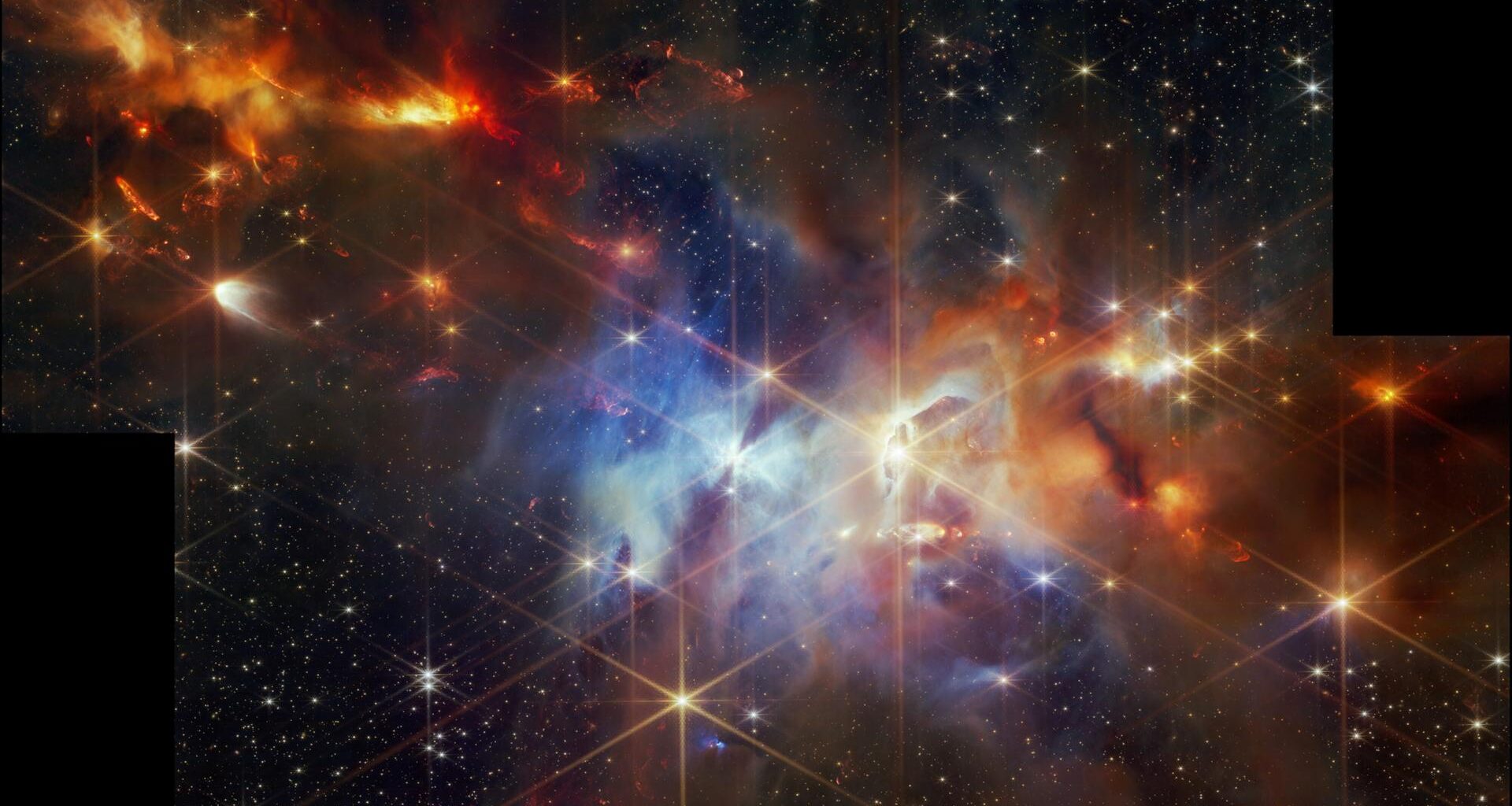 Die bunten Gas- und Staubwolken und die goldgelben Sterne mit ihren markanten Beugungsstrahlen geben dieser himmlischen Landschaft ein festliches Gepräge.