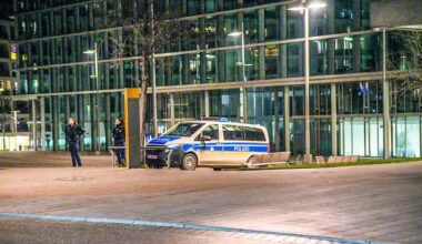 Ein Polizeifahrzeug steht am Stuttgarter Hauptbahnhof. Daneben stehen zwei Beamtinnen.