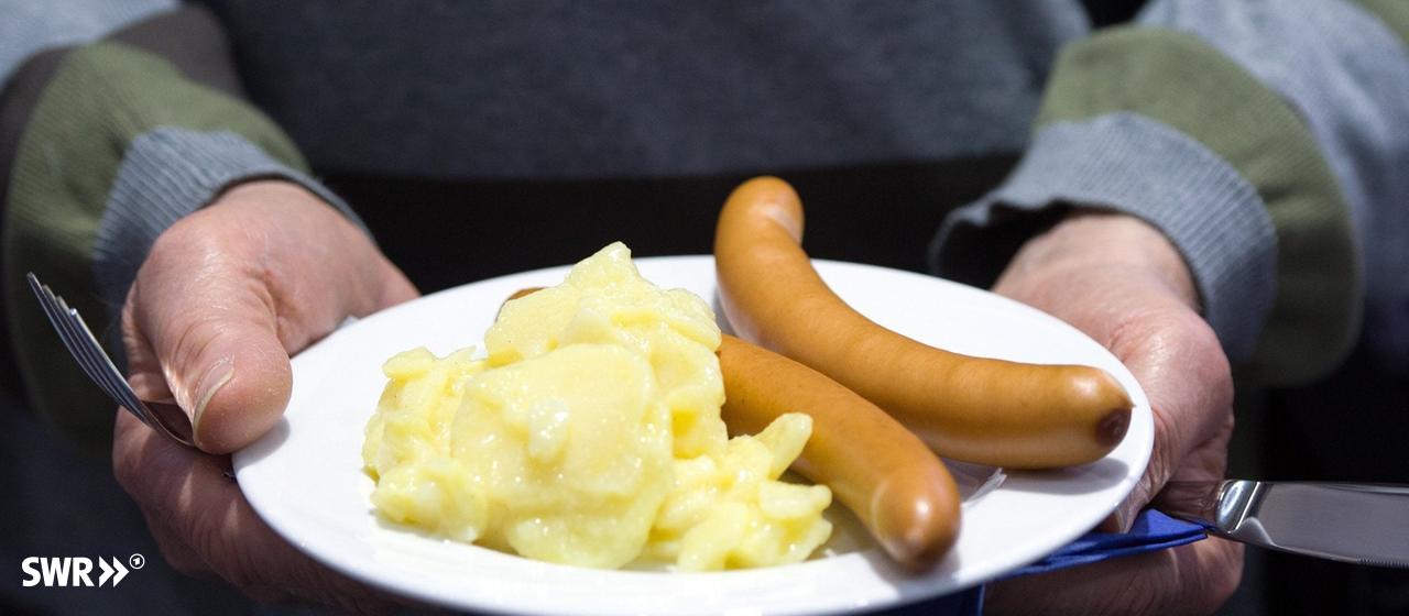Mit einem Weihnachtsessen und Heißgetränken haben Anwohnende die Feuerwehr während eines Einsatzes in Stuttgart versorgt. | dpa Bildfunk, picture alliance/dpa | Soeren Stache (Symbolbild) Weihnachtsessen für die Feuerwehr: Würstchen mit Kartoffelsalat liegen auf einem Teller.