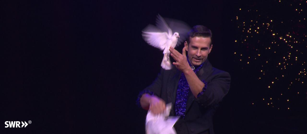 Zauberkünstler mit flatternde Taube in Hand