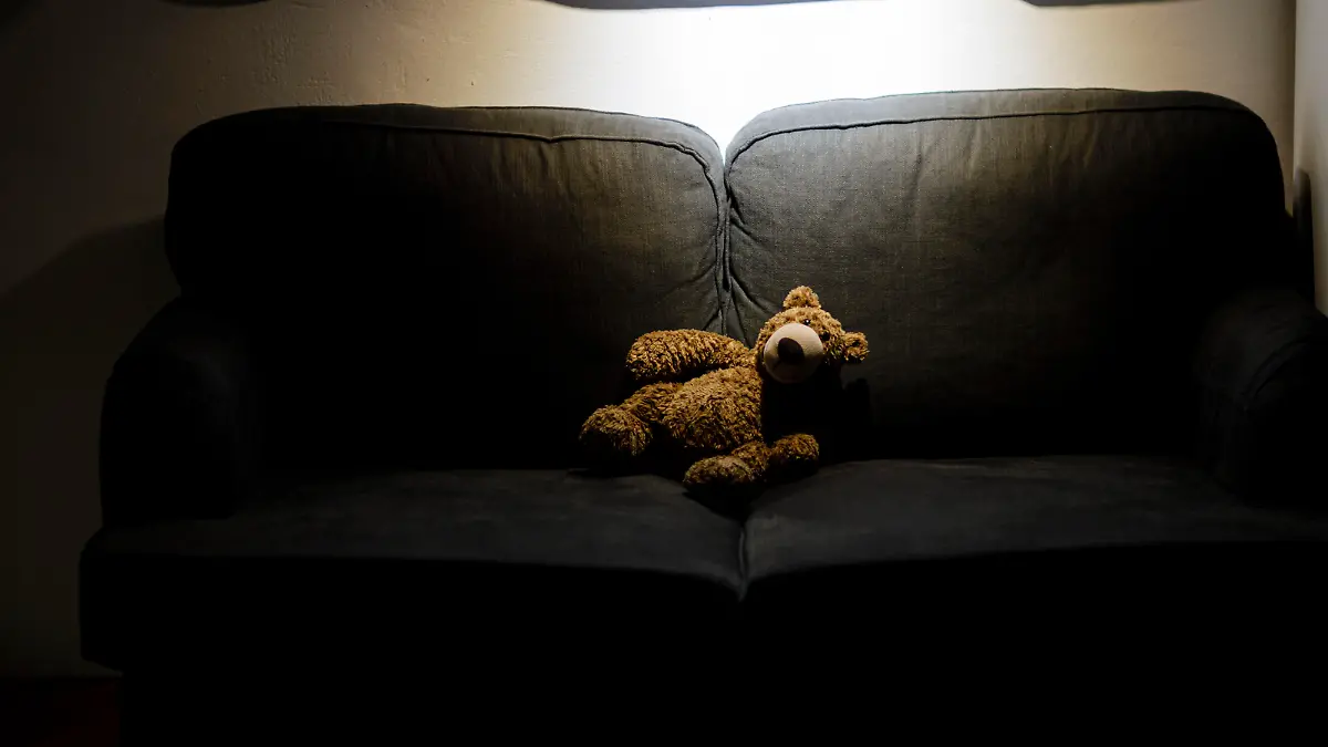 Symbolfoto zum Thema Kindesmissbrauch: Ein Teddy sitzt im Dunkeln allein auf einer Couch. Berlin, 25.03.2020.