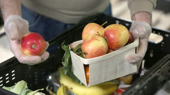 Ein Lebensmittellager der Tafel, im Vordergrund Äpfel. (Themenbild)
