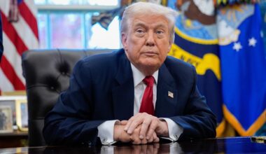 US-Präsident Trump sitzt an seinem Schreibtisch und blickt schräg an der Kamera vorbei.