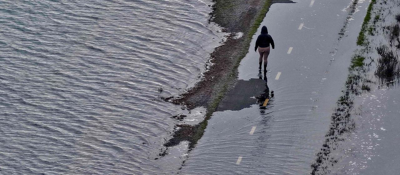 Luftaufnahme eines Fußgängers auf einer überfluteten Straße in Mill Valley, Kalifornien. | Getty Images via AFP Luftaufnahme eines Fußgängers auf einer überfluteten Straße in Mill Valley, Kalifornien.