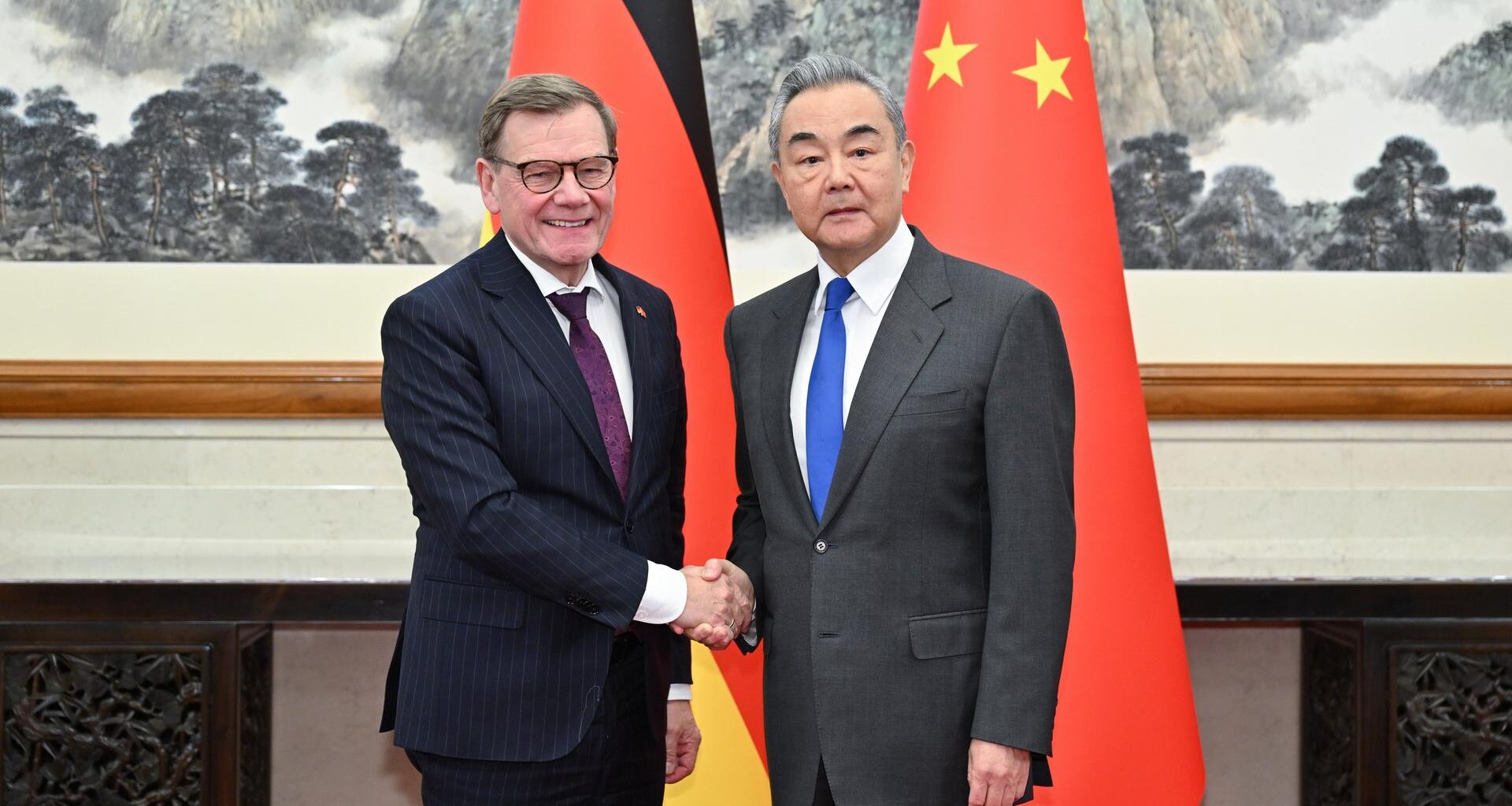 Bundesaußenminister Wadephul und sein chinesischer Amtskollege Wang stehen vor den Nationalflaggen beider Länder und geben sich die Hand.