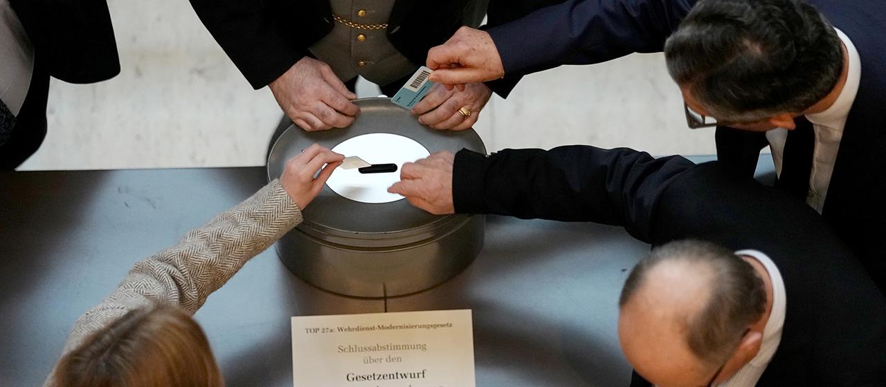 Abgeordnete geben ihre Stimmkarte im Bundestag ab.