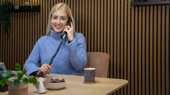 Ein sympatische junge Frau am Telefon