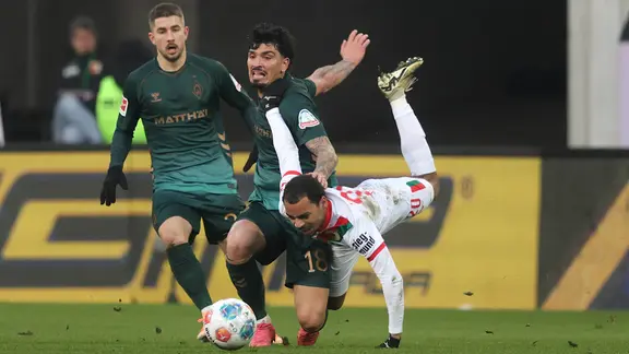 Werder-Profi Cameron Puertas (M.) im Zweikampf mit Augsburgs Alexis Claude-Maurice | IMAGO/Oryk HAIST Werder-Profi Cameron Puertas (M.) im Zweikampf mit Augsburgs Alexis Claude-Maurice