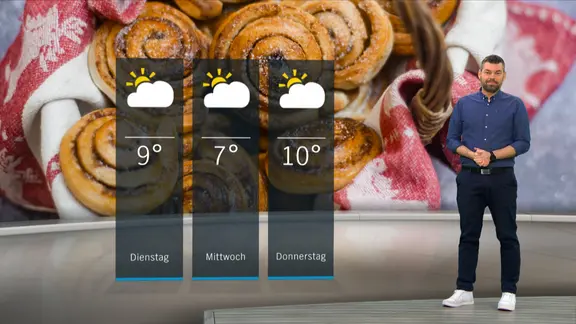 Wetterexperte Sebastian Wache steht im Studio mit der Wettervorhersage.