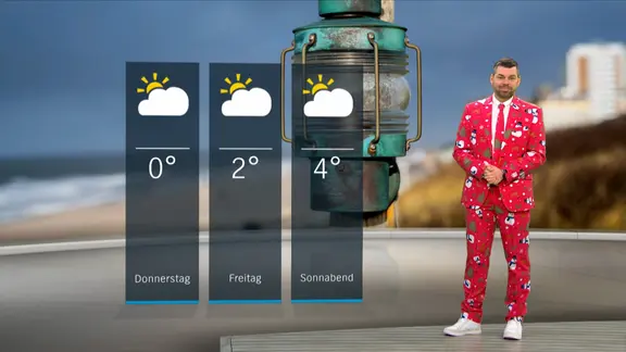 Wetterexperte Sebastian Wache steht im Studio mit der Wettervorhersage.